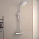 Duschsystem von Ideal Standard mit einer runden Brausestange und einem Kopf- sowie Handbrause. Die Ausstattung ist in Chrom gehalten und an einer hellen Wand montiert.